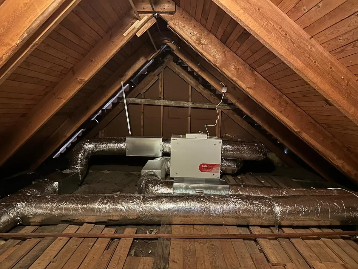 FTX-aggregat installerat på vinden i en villa – ett CASA Smart-aggregat anslutet till isolerade ventilationskanaler som distribuerar filtrerad tilluft och återvinner värme